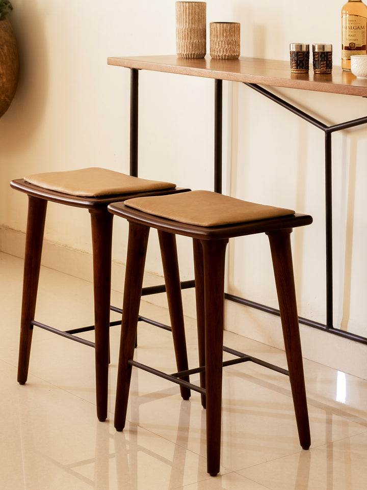 Two brown Tucker counter stools with solid acacia wood legs and leather seating, set in a modern kitchen environment.